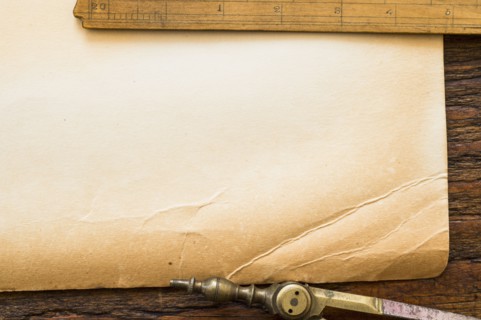 Old brown paper with ruler and compass, studio shot.