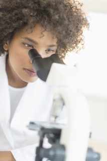 Woman using microscope in laboratory.
