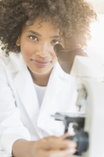 Woman using microscope in laboratory.