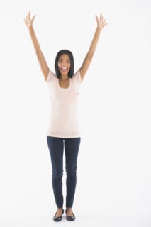 Portrait of woman with arms up, studio shot.