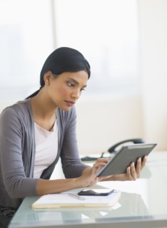 Businesswoman using digital tablet in office.
