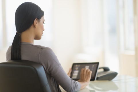 Businesswoman using digital tablet in office.