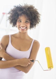 Portrait of woman holding paint roller.