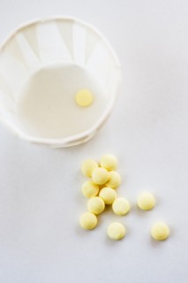 Yellow pills with cup, studio shot.