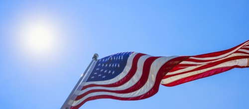 US flag against blue sky.