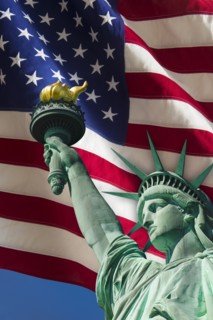 Statue of liberty under US flag.
