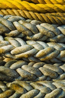 Braided ropes in harbor, close-up.
