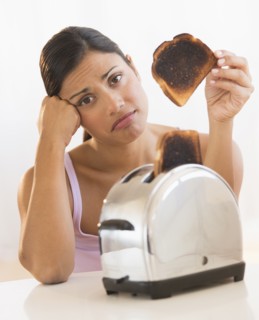 Studio shot of woman holding burnt toast.