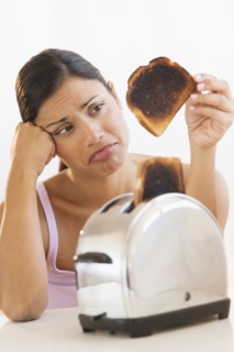 Studio shot of woman holding burnt toast.