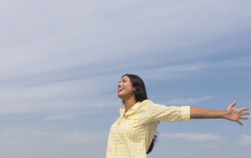 Happy woman against blue sky .