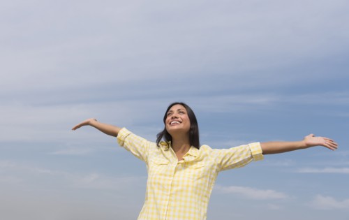 Happy woman against blue sky .