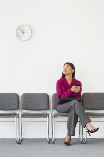Woman sitting in waiting room and text messaging.