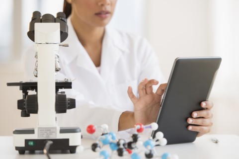 Female scientist working on tablet PC .