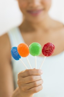 Woman holding colorful lollypops.