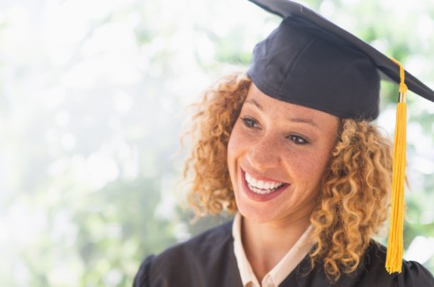 Portrait of smiling young woman in mortarboard.