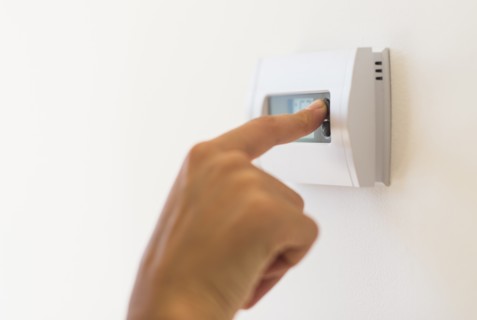 Young woman setting air conditioning.