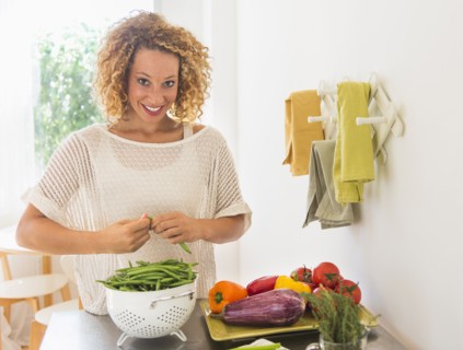 Young woman preparing food in kitchen.