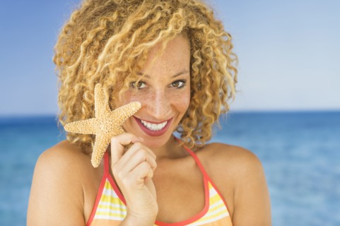 Portrait of young woman holding starfish.