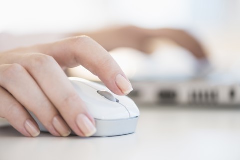 Close up of woman's hands using computer mouse.