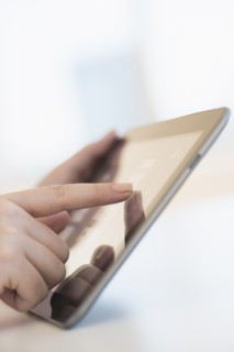 Close up of woman's hands using digital tablet.