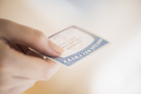 Close up of woman's hand holding social security card.