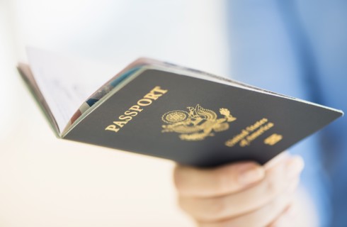 Close up of woman's hand holding open passport.