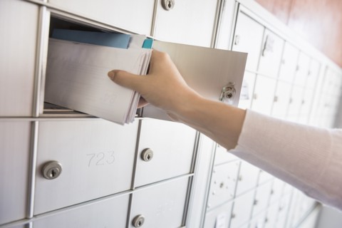 Woman taking letters from safety deposit box.