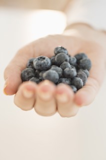 Blueberries on woman's hand.