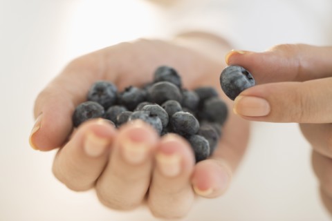 Blueberries on woman's hand.