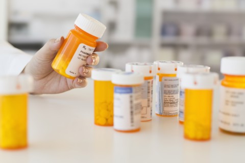Pharmacist holding pill bottle.