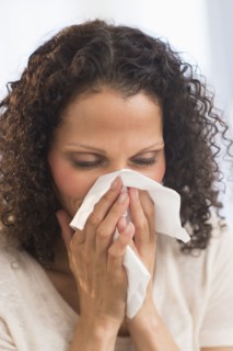 Portrait of woman blowing nose.