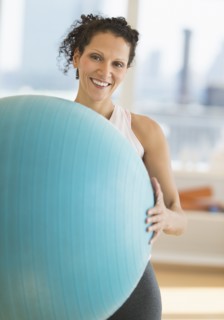 Portrait of woman exercising with exercise ball.