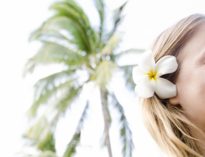 Woman wearing plumeria flower in hair. Photo : Jamie Grill