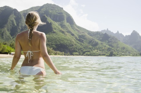Tunnels Beach, Woman walking in sea. Photo : Jamie Grill