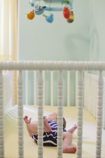 Baby girl (2-5 months) in crib. Photo : Jamie Grill