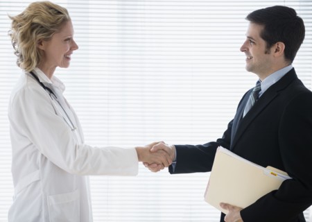 Female doctor greeting office worker. Photo : Jamie Grill