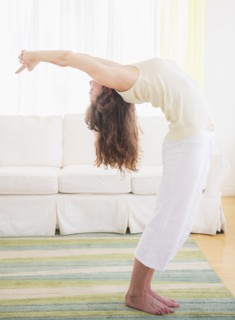 Young woman exercising at home. Photo : Daniel Grill