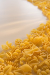 Variety of yellow pasta with blank white space in upper left corner. Photo : Daniel Grill