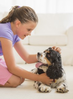 Girl (8-9) playing with her dog . Photo: Daniel Grill