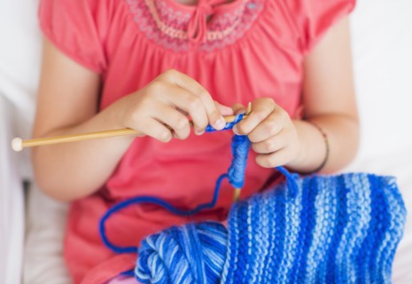 Young girl (8-9) knitting . Photo : Daniel Grill