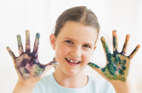 Young girl (8-9) showing hands stained with paint. Photo : Daniel Grill