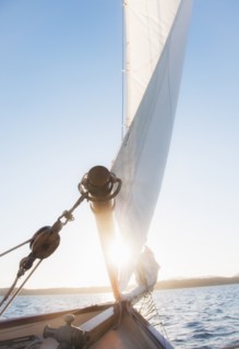 View of sea with yacht bow and sail in foreground. Photo : Daniel Grill