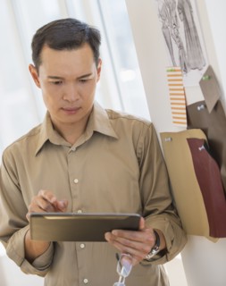 Mid adult fashion designer using digital tablet. Photo : Daniel Grill