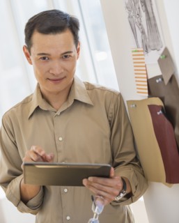 Mid adult fashion designer using digital tablet. Photo : Daniel Grill