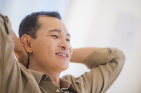 Profile of happy mid adult man with hands behind his back. Photo : Daniel Grill