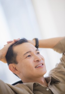 Profile of happy mid adult man with hands behind his back. Photo : Daniel Grill