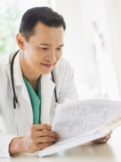 Doctor examining medical records. Photo : Daniel Grill