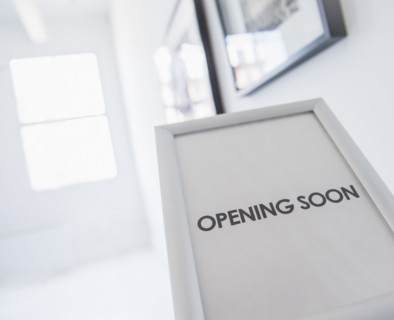 Opening sign with pictures on white wall in background. Photo : Daniel Grill