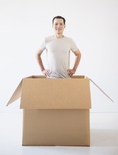 Man popping out from cardboard box. Photo : Daniel Grill