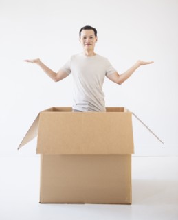 Man popping out from cardboard box. Photo : Daniel Grill